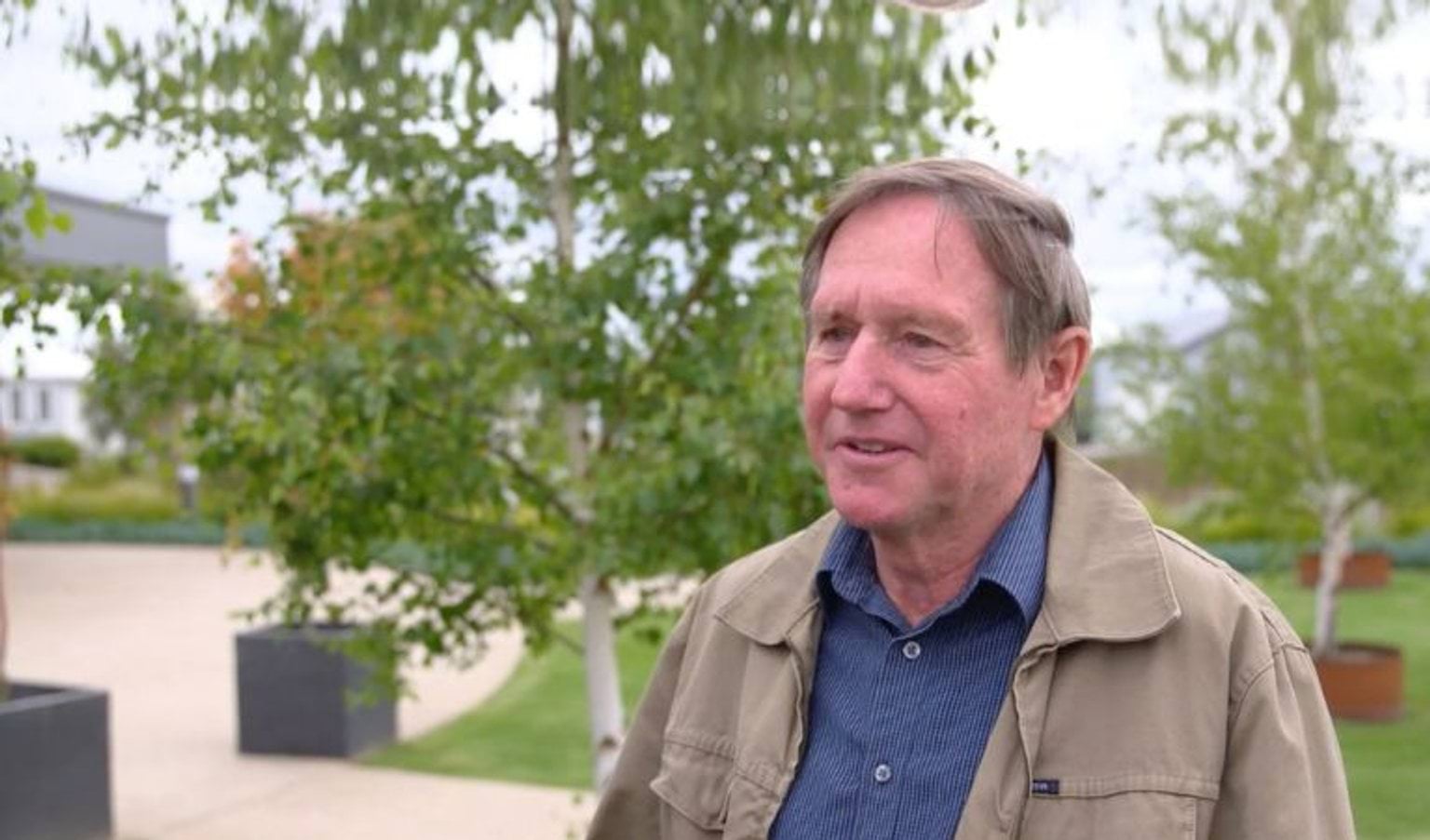Solar Superheroes - Skylark Boulevard A man in anavy shirt and tan jacket talks to the camera.