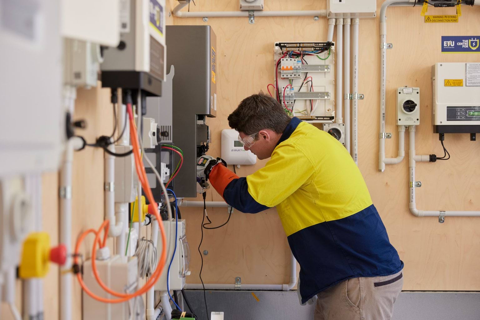 Electrician conducting a switchboard upgrade in a training setting