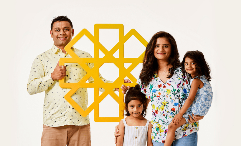 Family standing together, holding yellow cardboard sun