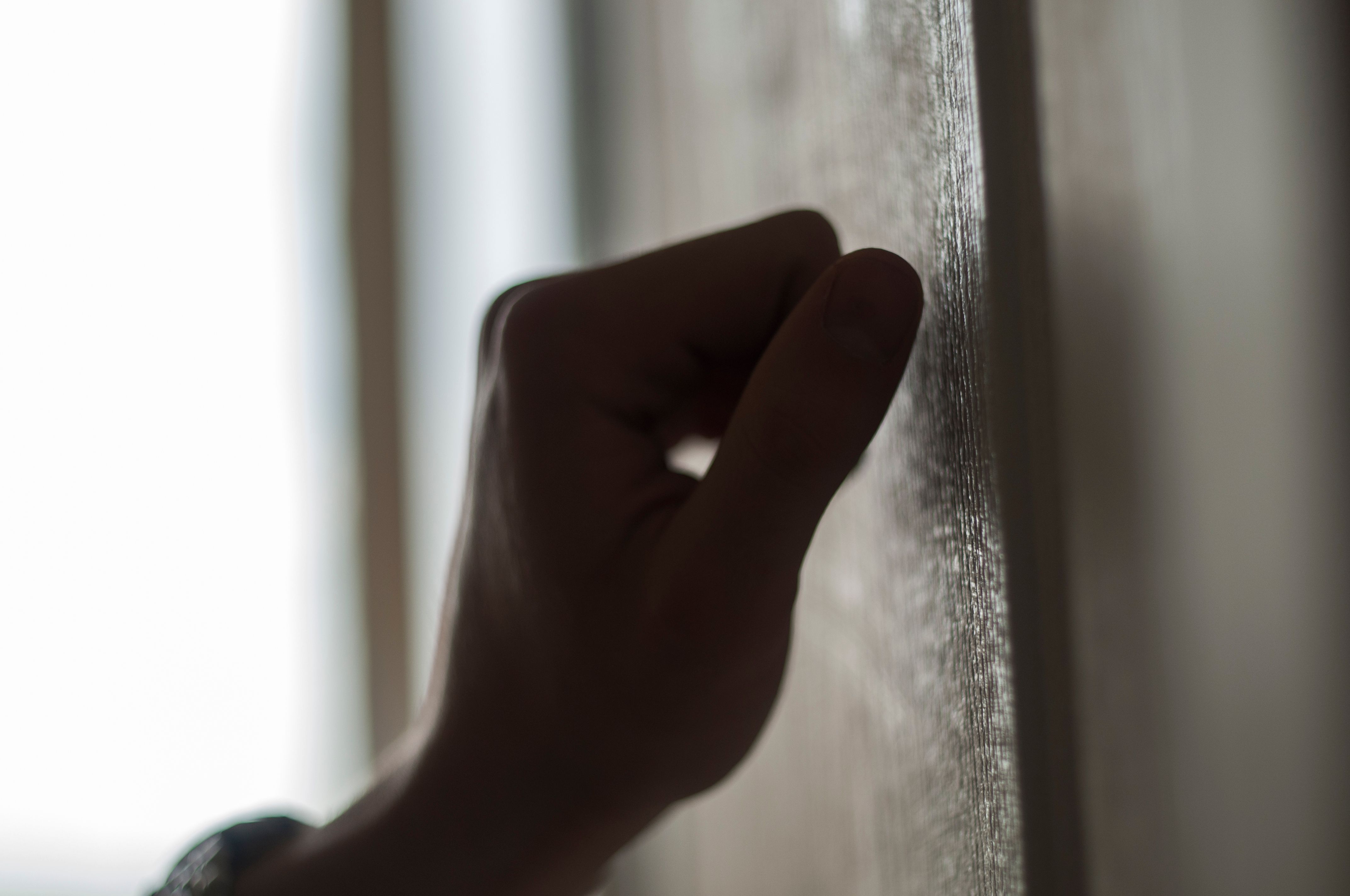 Hand knocking on wooden door