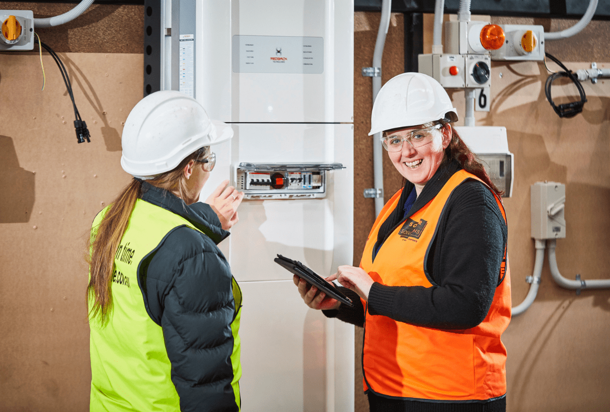 Two women working in solar at a job site. 